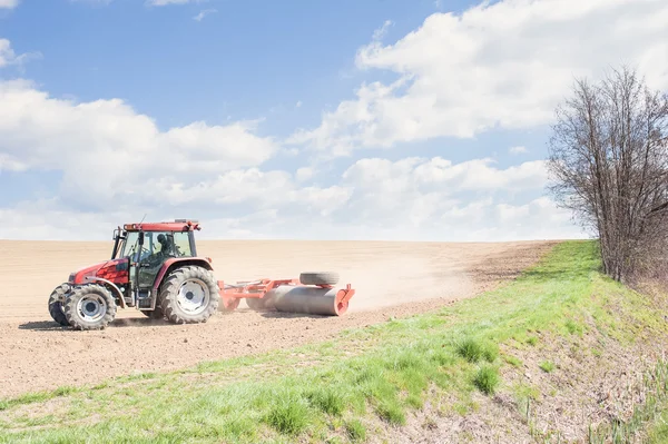 Traktor tömöríti a talaj görgőkkel ültetés után. — Stock Fotó