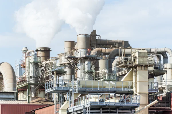 Impianto industriale di una fabbrica di mobili con ciminiere fumanti — Foto Stock