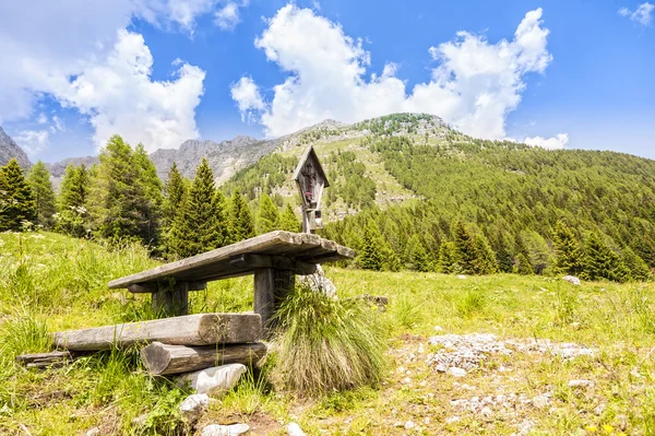 Panorama de montanha com mesa e bancos para descanso e crucifi — Fotografia de Stock