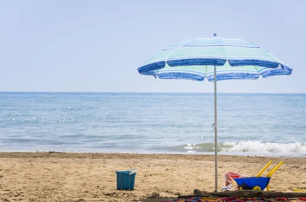 Зонтичный пляж и детские пляжные игрушки — стоковое фото