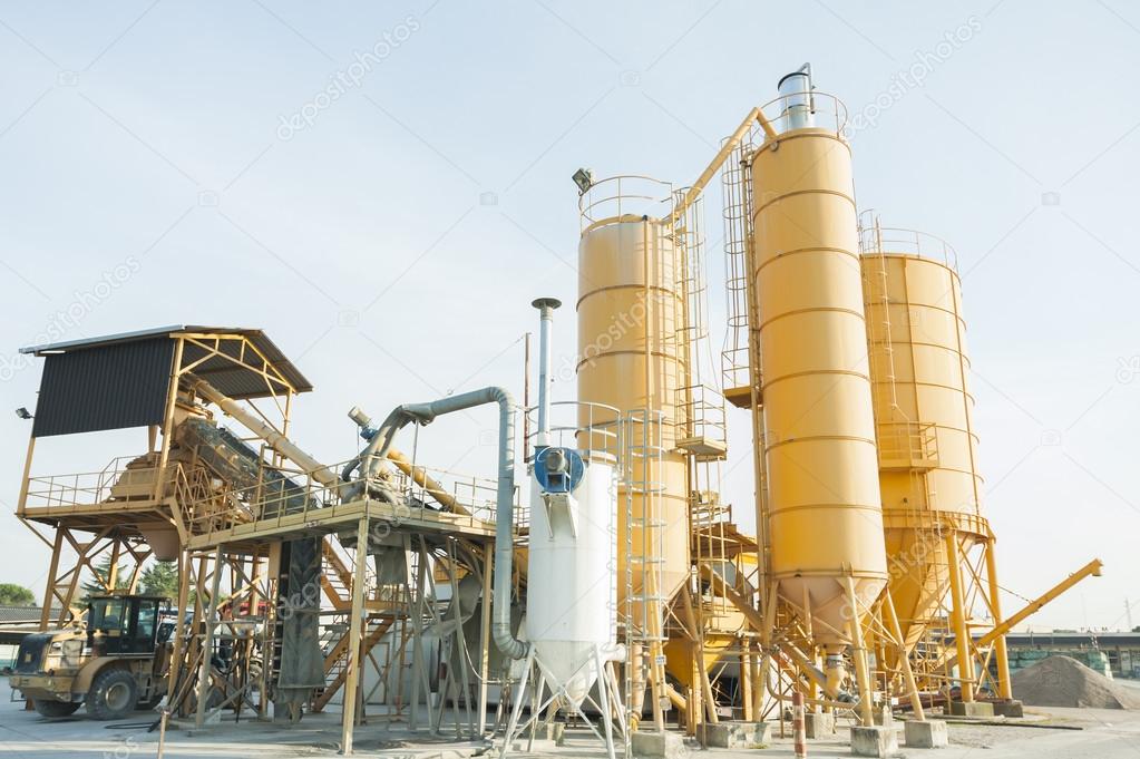 Plant for production of concrete with silos and excavator.