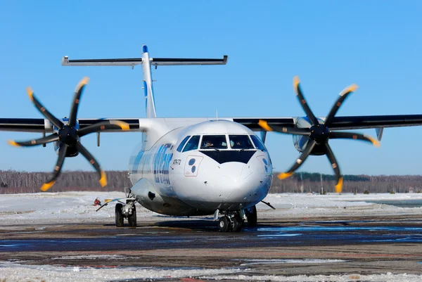 The passenger ATR-72 plane of the company Utair the Express with the rotating propellers