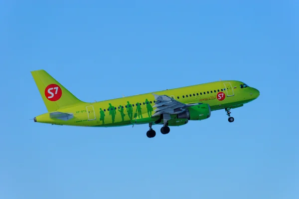 Nizhny Novgorod. Russia. February 17, 2015. The bright green passenger plane of the s7 company in the clear blue sky Royaltyfria Stockfoton