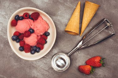 Kurabiye külahında çilekli dondurma, dondurma kepçesi, çilek ve çilek.