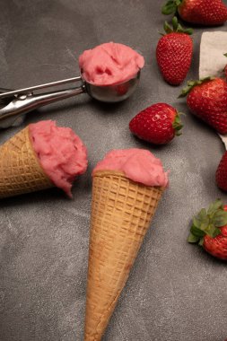 Kurabiye külahında çilekli dondurma, dondurma kepçesi, çilek ve çilek.