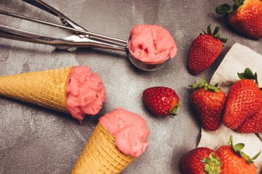 Kurabiye külahında çilekli dondurma, dondurma kepçesi, çilek ve çilek.