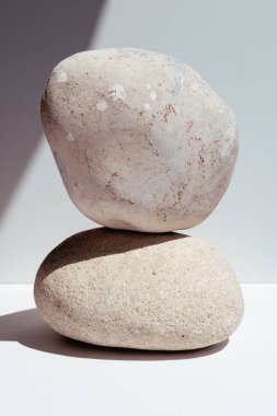 Taşları dengelemek. Beyaz arka plandaki spa tedavileri için taşlar. Taşlar üzerinde meditasyon kavramı bir piramidin içinde duruyor..