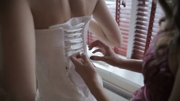 Lacing up a corset of a wedding dress — Stock Video