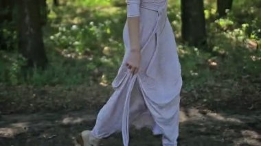 Kadın bir ormanda yürüyüş ışığı elbiseyle, park