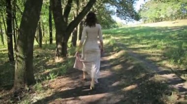 Kadın bir ormanda yürüyüş ışığı elbiseyle, park
