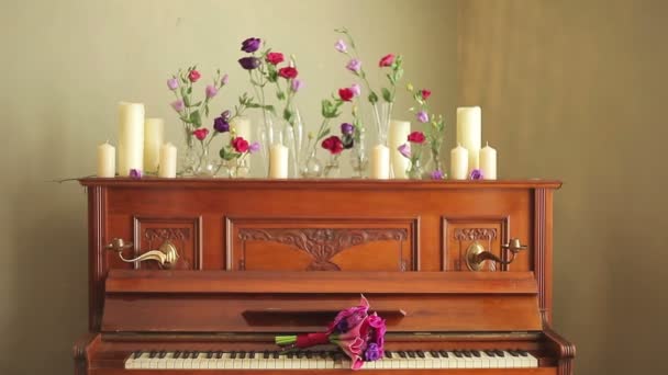 Gamla vackra piano med Buketter av blommor och ljus — Stockvideo