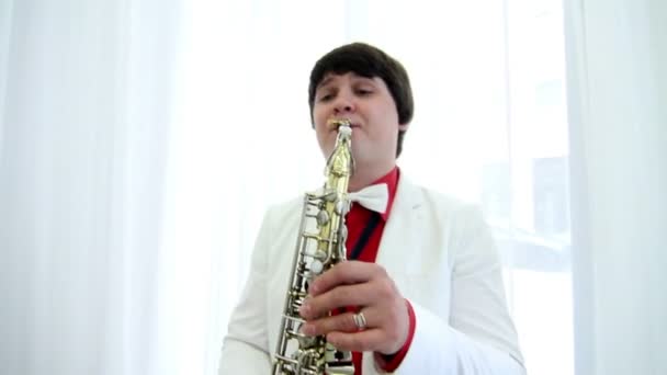 Человек в праздничном костюме играет на саксофоне — стоковое видео