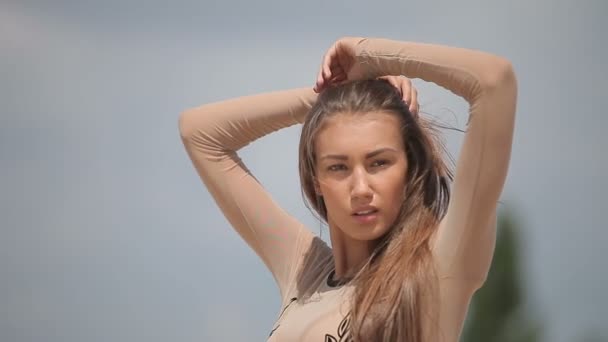 Jovem mulher atraente em um vestido sexy slinky transparente, posando ao sol — Vídeo de Stock