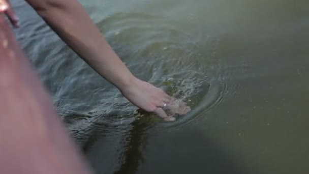 La mano se desliza sobre el agua en un día soleado — Vídeo de stock