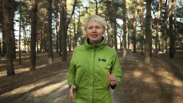 Mooie actieve atlete joggen buiten in de zonnige dag. Uitgevoerd in het hout. Gezonde vrouwen. — Stockvideo