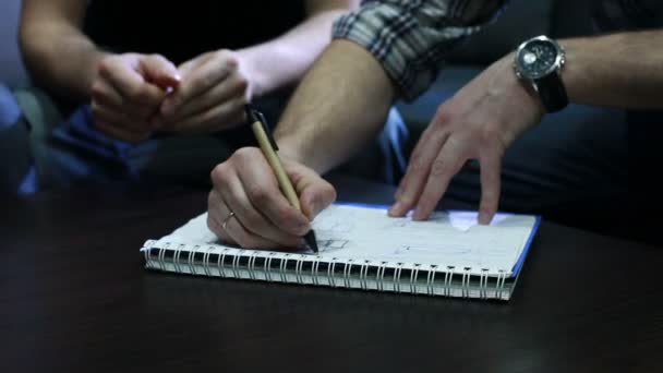 Σχέδιο σχέδιο. Τα χέρια των νέων που σύρει ένα σχέδιο με στυλό για φορητό υπολογιστή στο γραφείο κατά τη διάρκεια της συνεδρίασης. Κοντινό πλάνο — Αρχείο Βίντεο