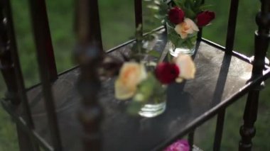 Ahşap antika küçük cam vazo içinde gül demetleri standı.