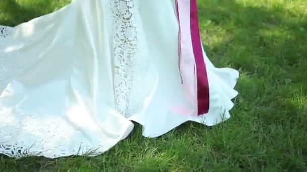 Vestido de novia con tren. hermoso ramo de flores en las manos de la novia joven. Bodas. mujer joven en el parque, bosque. celebración de la boda. naturaleza fondo verde. estilo de vida pareja familia — Vídeo de stock