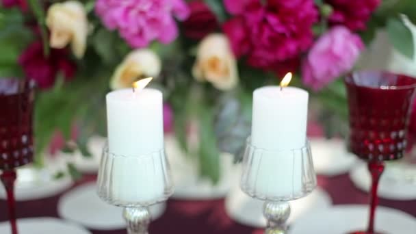 Decoración de la mesa de boda en la naturaleza con velas encendidas, primer plano. Steadicam tiro — Vídeos de Stock