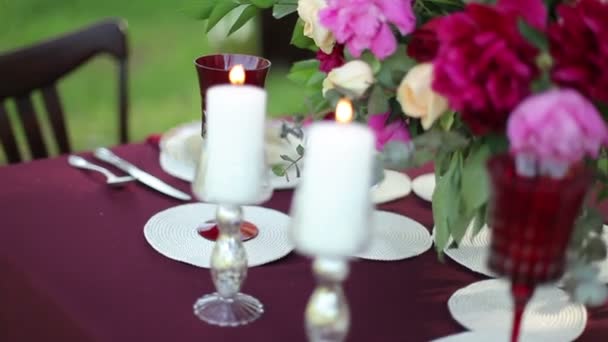 Decoração de mesa de casamento na natureza com velas acesas, close-up. Steadicam tiro — Vídeo de Stock