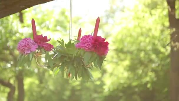 Hochzeitstisch-Dekor mit hängenden Kerzen, die mit zarten Blumen geschmückt sind. Hochzeit im Garten, Park. außerhalb der Trauung. — Stockvideo