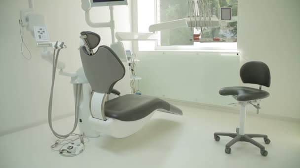 Het interieur van de tandheelkundige kliniek met stoel en hulpprogramma's. Hedendaagse lege tandheelkundige kantoor met tandheelkundige stoel en apparatuur. — Stockvideo