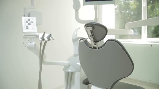 Het interieur van de tandheelkundige kliniek met stoel en hulpprogramma's. Hedendaagse lege tandheelkundige kantoor met tandheelkundige stoel en apparatuur. — Stockvideo