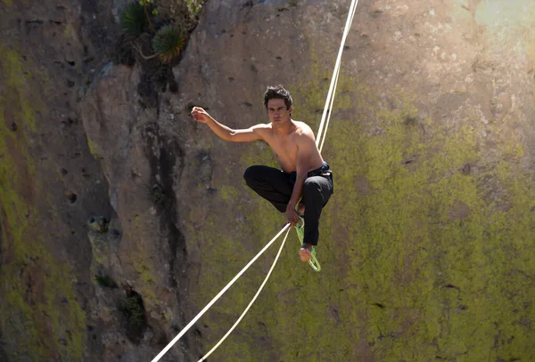 Genç Latin adam, dağlarda, doğada ip cambazlığı yapıyor. ekstrem spor.