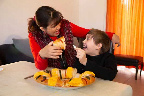 Aile geleneksel Rosca de Reyes 'i paylaşır. Çocuk kralın vida kekinde oyuncak bebek buluyor.