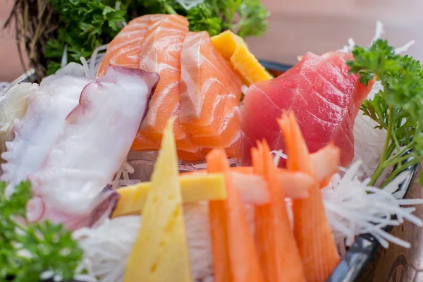 Un piatto colorato di sushi sashimi con tonno e bastoncini di granchio - Punto focale selettivo Fotografia Stock