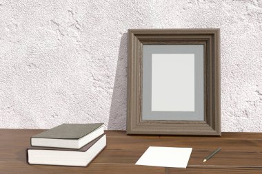 Boş fotoğraf çerçevesi ve masanın üzerindeki kitaplar.