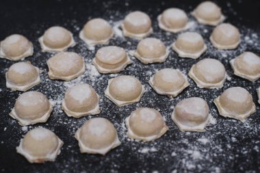 Siyah arka planda un serpiştirilmiş ev yapımı hamur tatlısı, yemek fotoğrafı.