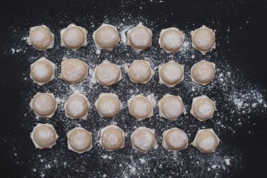 Siyah arka planda un serpiştirilmiş ev yapımı hamur tatlısı, yemek fotoğrafı.