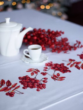 Rowan dalları, kırmızı böğürtlenler ve bir fincan kahveyle Noel süslemesi.