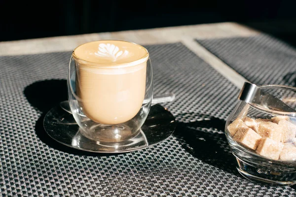 Sabah güneşli bir masada şeffaf bir fincanda kahve.