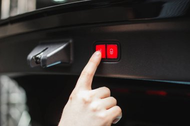 Erkek sürücü, arabasının ayarlarını düğmeleriyle kontrol eder