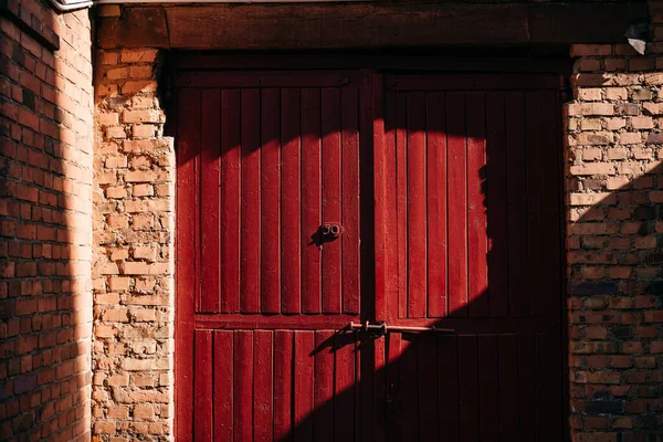 Oude rode houten deuren in een bakstenen gebouw — Stockfoto