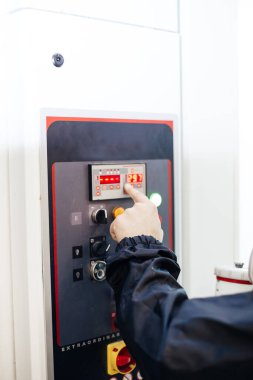 Fabrikadaki makine işletim konsolunun önündeki erkek operatör. 