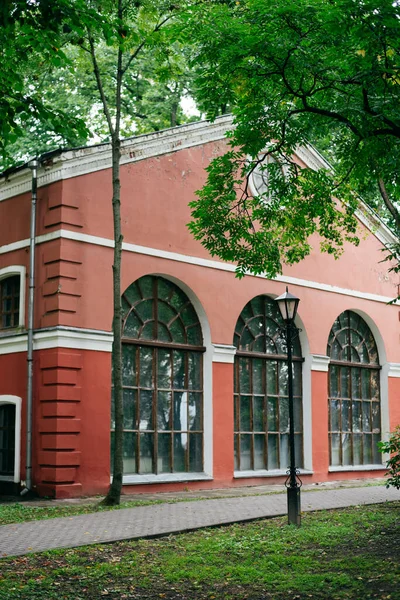 Klein roze huis met een groot gewelfd raam en betegeld dak. — Stockfoto