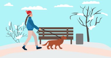 Kışın köpeğiyle gezen genç bir kadın.