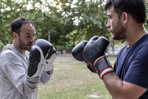 View of two persons looking each other in the eyes after a training day, two persons doing boxing exercise concept in Lisbon, Portugal.