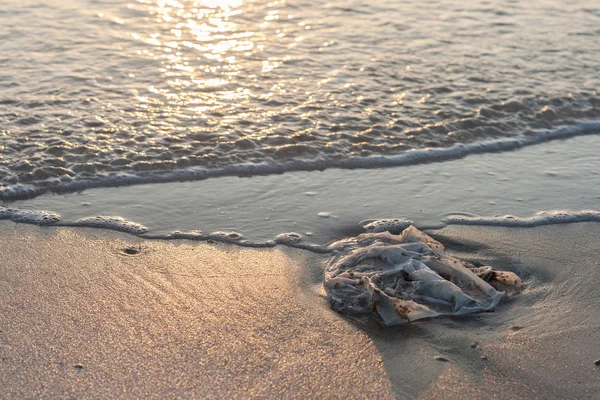 Використана пластикова сумка сміття на піщаному пляжі — стокове фото