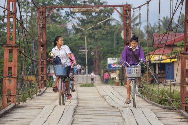 Vang Vieng, Laos - 7 Aralık 2012: Tahta Köprü 'de okuldan dönen kimliği belirsiz genç kız.