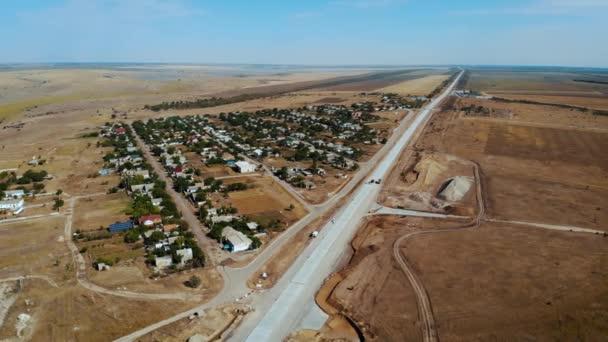 Vista aérea da construção de novas estradas ao longo da pequena aldeia europeia com pequenas ruas empoeiradas — Vídeo de Stock