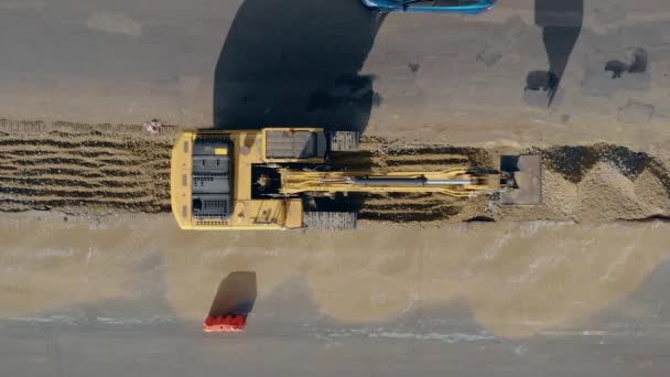 Vista superior aérea en el terreno de excavación de la excavadora de orugas para el camino de revisión — Vídeo de stock