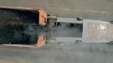 Paver kamyonun içine toz dolduruyor. Eski asfalt katmanını değirmen ve öğütme makinesiyle kapatıyoruz. Yol inşaatı