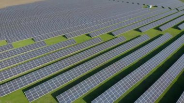 Baharda veya sonbaharda güneşli bir günde yeşil tarım arazilerindeki güneş enerjisi santrali