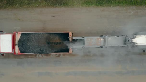 Detailní záběr frézy nebo brusky odstraní použitou vrstvu asfaltu a pomocí pásového nakladače ji naplní do karoserie sklápěcího vozu — Stock video