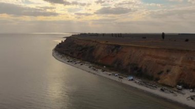 Deniz kıyısında bulutlu gün batımı ve harika bir kamp.