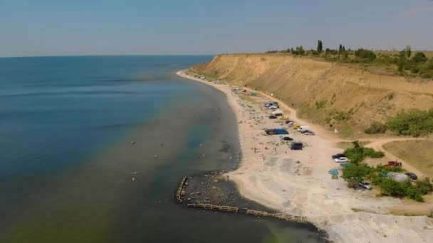 Viajantes descansando na praia abandonada do mar selvagem na costa acampar perto do penhasco — Vídeo de Stock